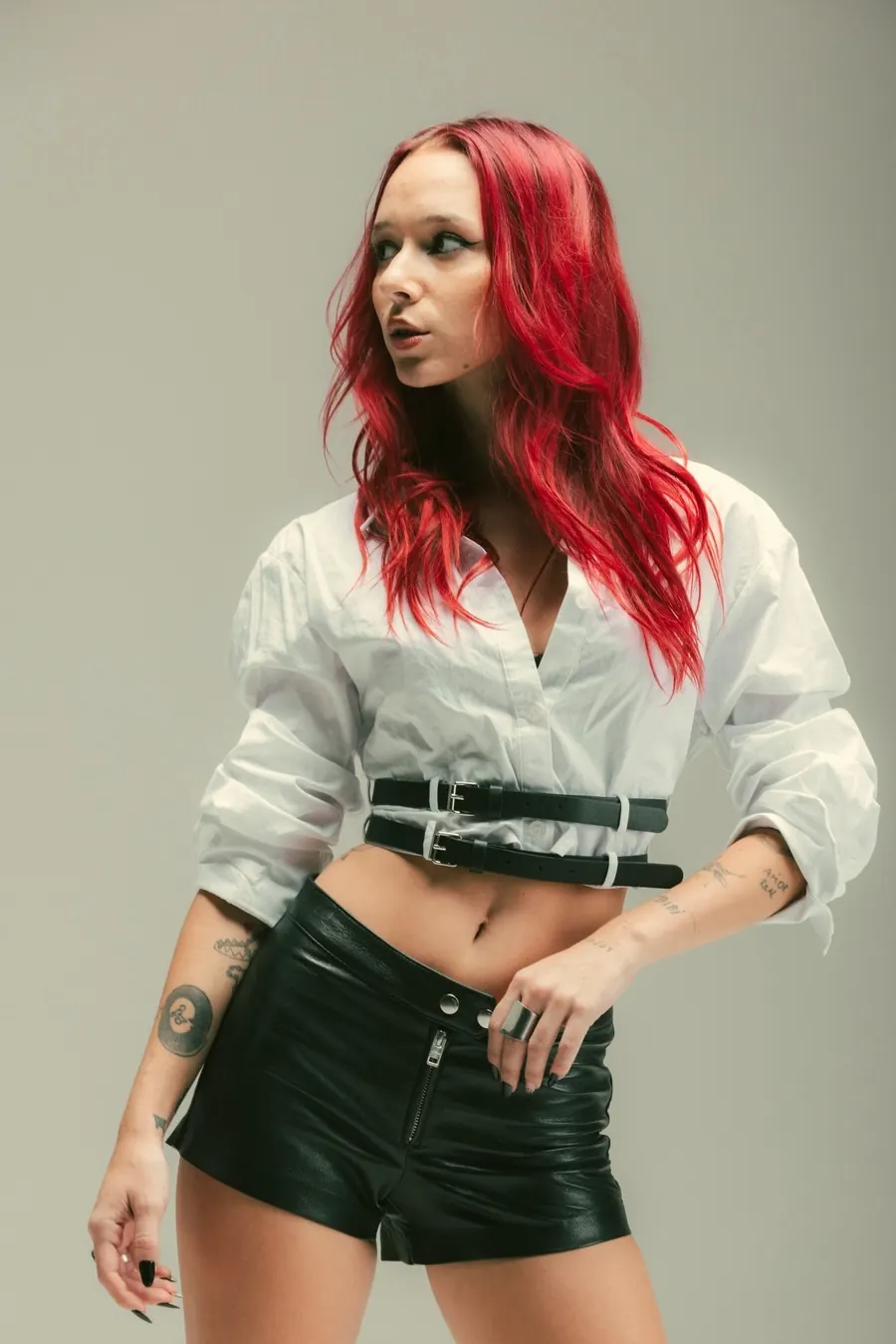 Luana Digier de pie con camisa blanca y cinturones negros
